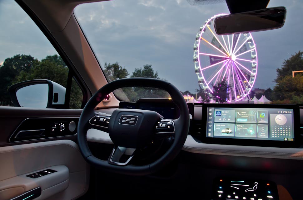 Hoekig stuurwiel Aiways U5, verlicht reuzenrad, Ferris Wheel, fair, digitaal multimediascherm, verlichte knopjes in interieur, donkere lucht