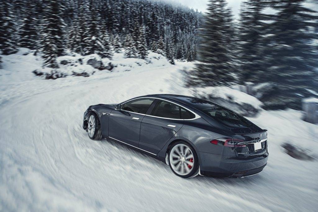 grijze Tesla Model S rijdend in de sneeuw 